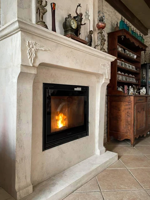 Intérieur résidentiel avec cheminée à foyer fermé en fonctionnement, feu de bois actif visible à travers les portes vitrées