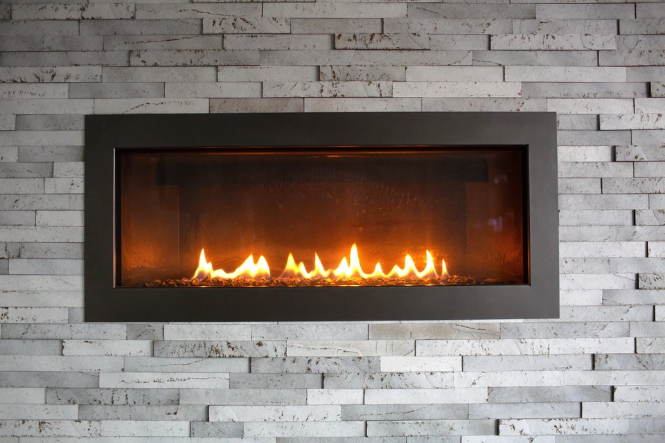 Intérieur résidentiel avec cheminée en briques rouges équipée d'un insert de chauffage au bois