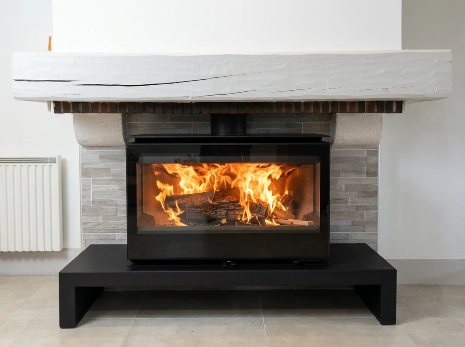Poêle à bois cylindrique noir mat installé dans un salon, en fonctionnement avec flammes visibles
